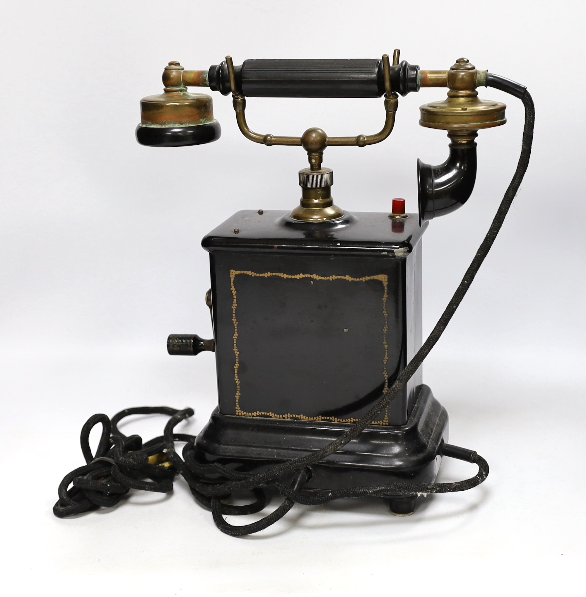 An early 20th century black enamelled metal telephone, 34cm high